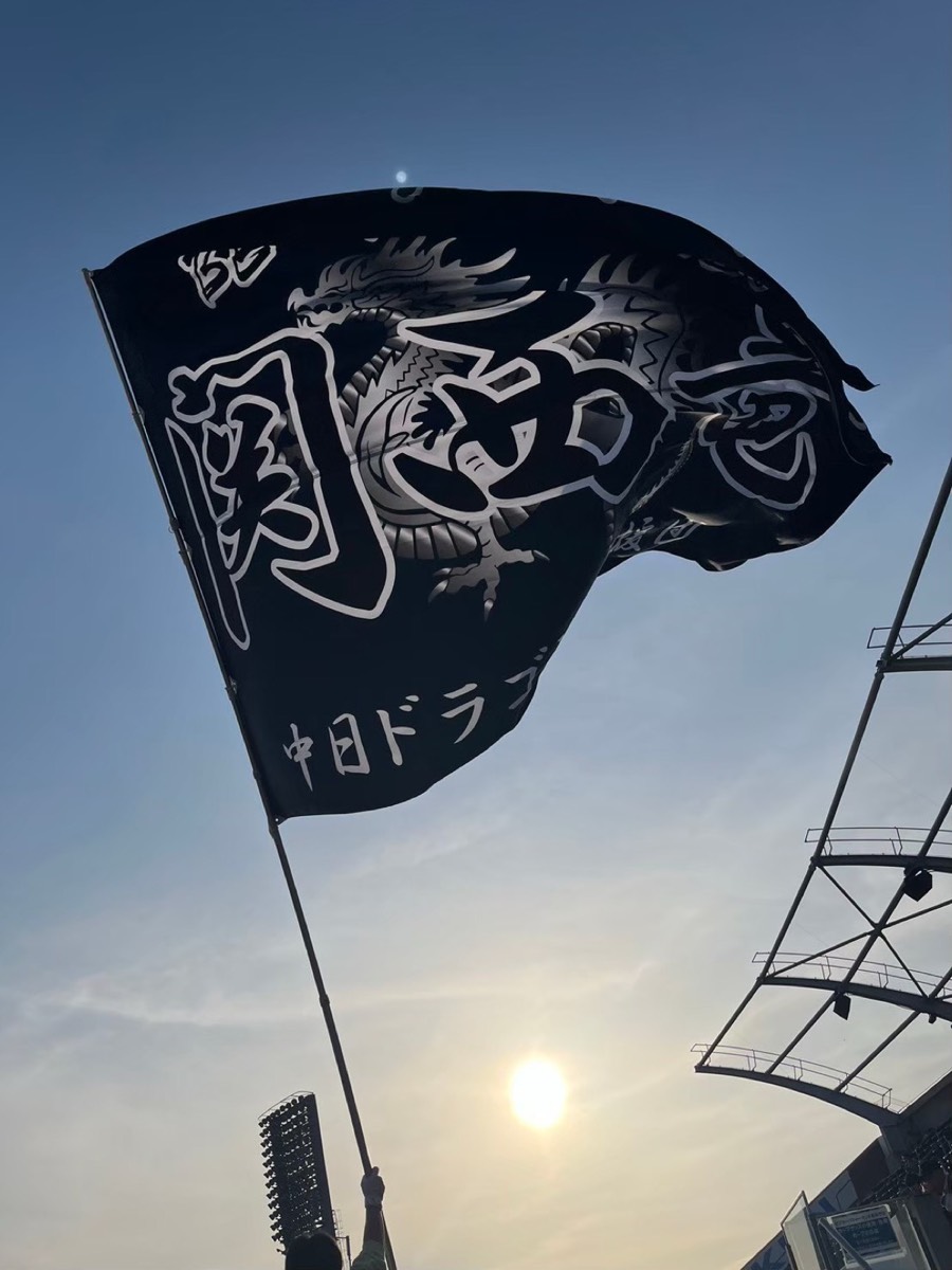 夕日の中でひるがえる「関西竜」旗