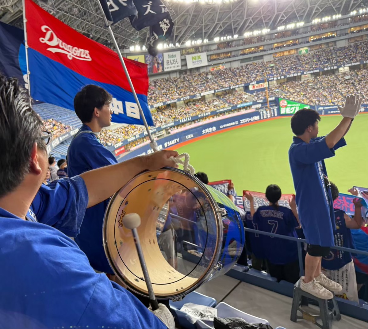 京セラドーム大阪でドラムを構える団員と、旗を振る団員